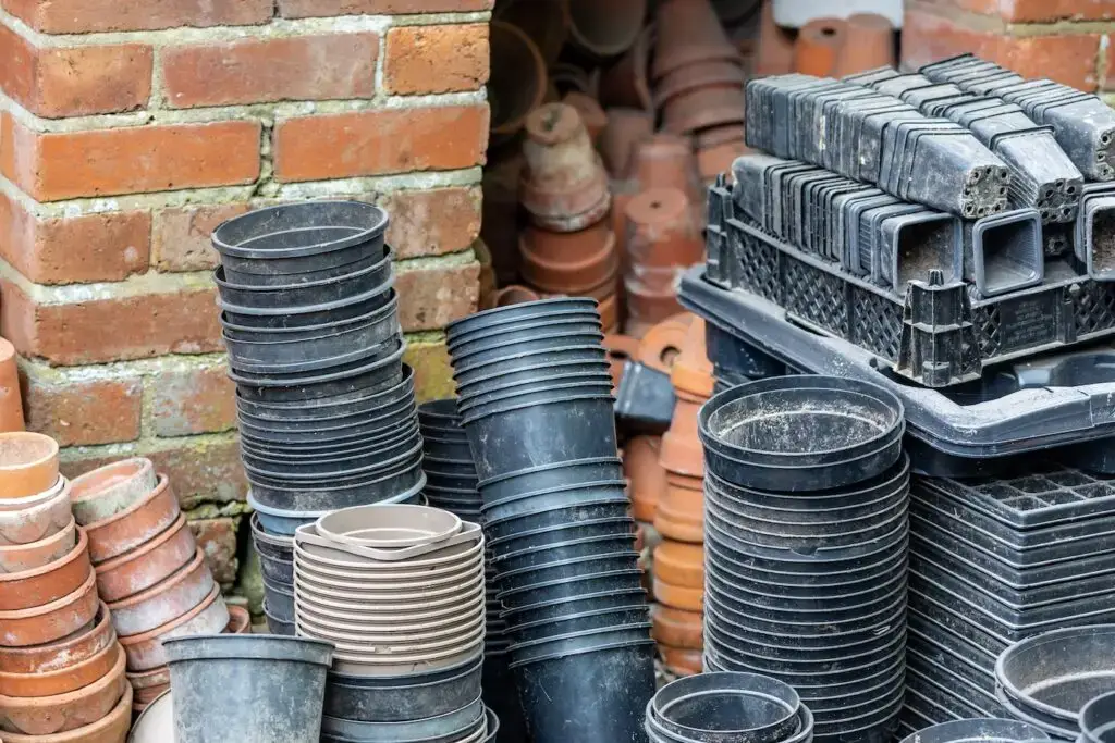 An abundance of stacked, empty plastic and terracotta plant pots, with a shallow depth of field