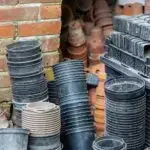 An abundance of stacked, empty plastic and terracotta plant pots, with a shallow depth of field