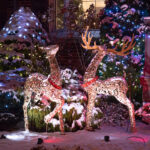 Décorations extérieures de Noël avec deux rennes lumineux et un sapin enneigé illuminé de guirlandes
