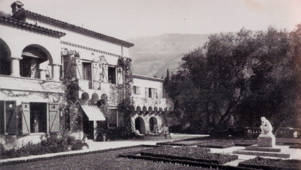 Vue ancienne de la villa Val Rahmeh à Menton, entourée de ses jardins avec une statue au premier plan.