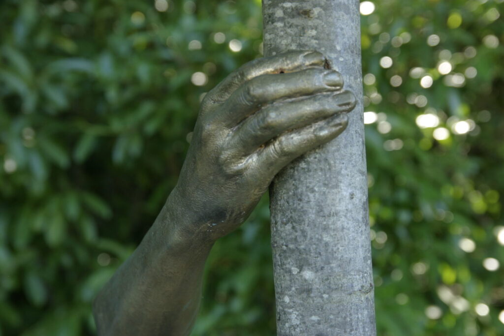 Main en bronze fixée à un tronc d’arbre, œuvre contemporaine dans le parc du domaine de Chaumont-sur-Loire.
