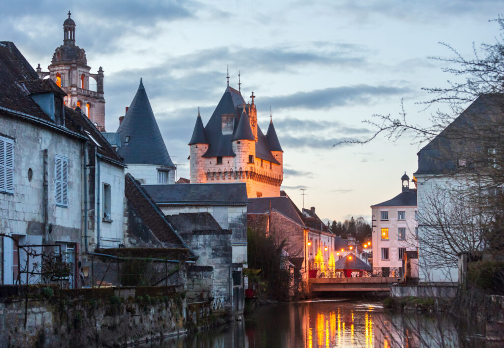 Vue sur les toits de Loches avec le clocher de Saint-Antoine et le château royal, au crépuscule, depuis les rives de l’Indre.