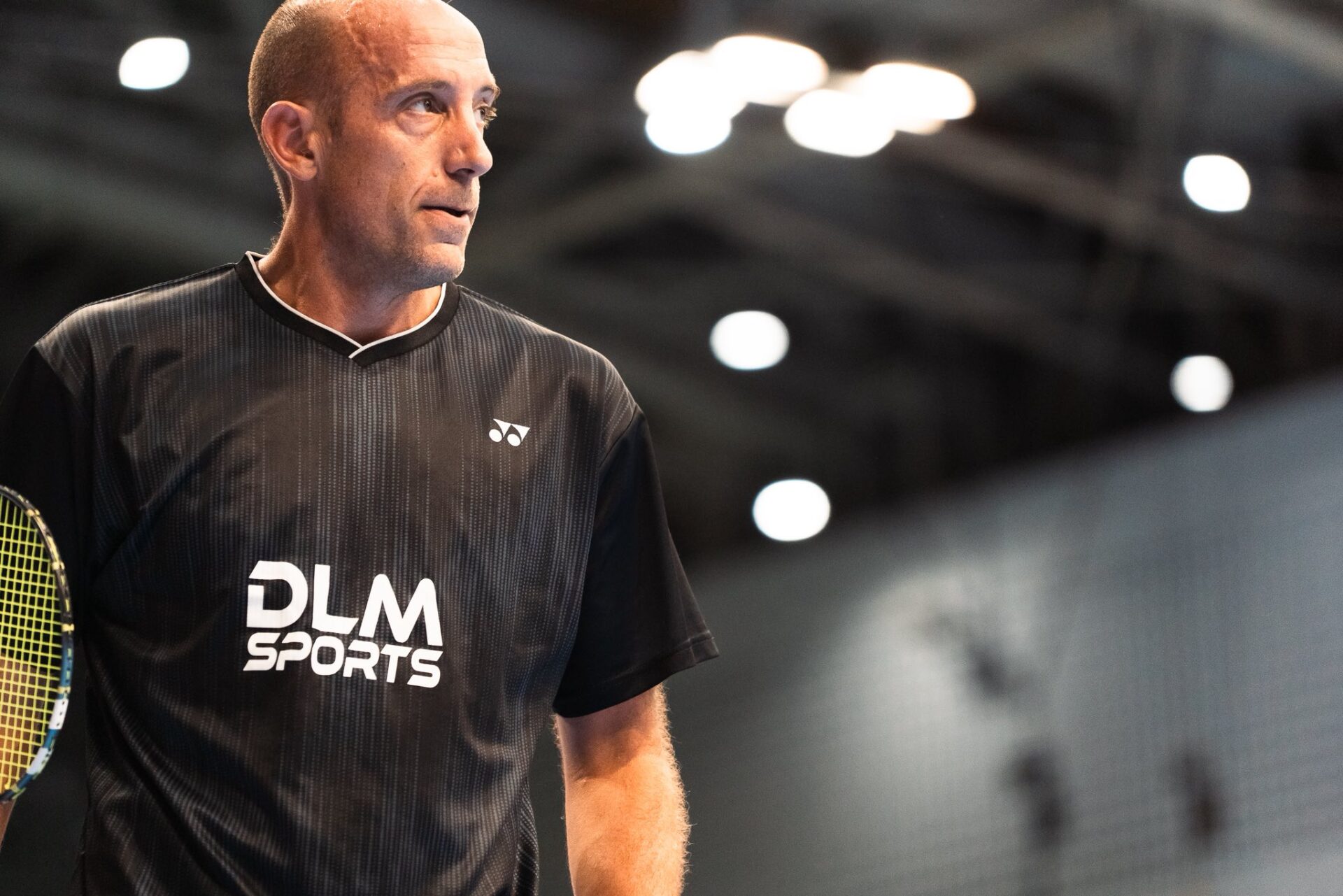 Éric Wasylyk concentré sur le terrain, raquette en main, lors d’un match international de badminton