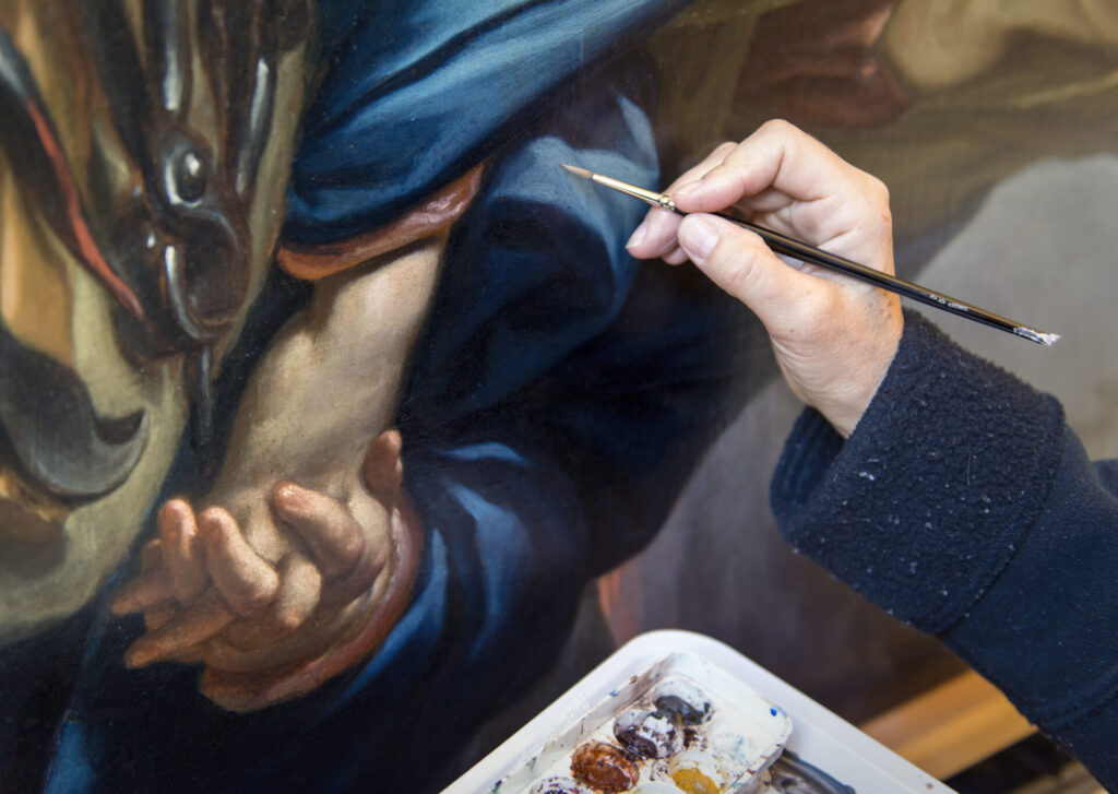 Geste précis de restauration d’un tableau ancien au pinceau fin
