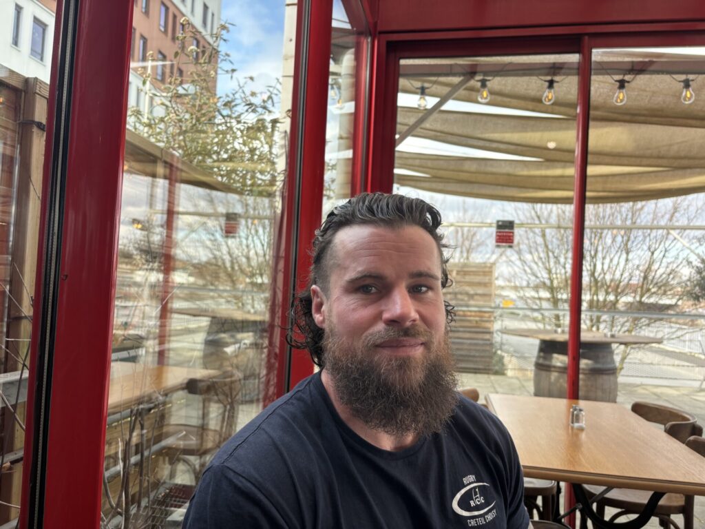 Portrait d’Elmo Gallego-Marcellan, éducateur sportif à Choisy-le-Roi, photographié en terrasse.