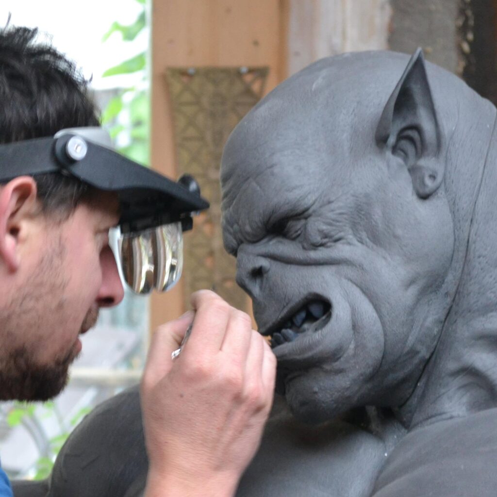 Fred Wajeman réalise les finitions d’une sculpture représentant une créature fantastique dans son atelier.