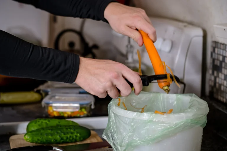 Épluchures de carotte déposées dans un sac compostable